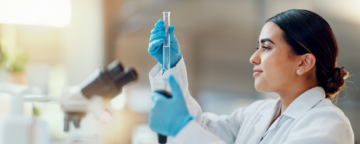Image of a scientist examining a beaker.