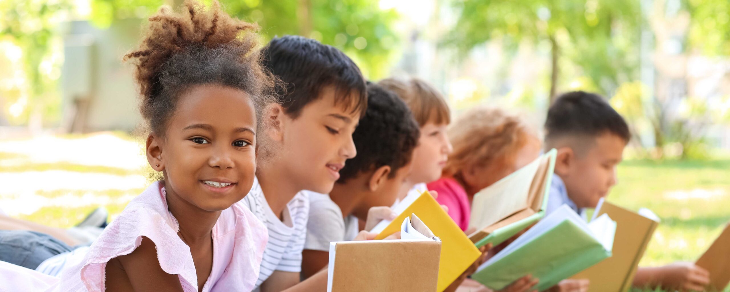 Image of kids reading outside for a release about the LAIC civics award.